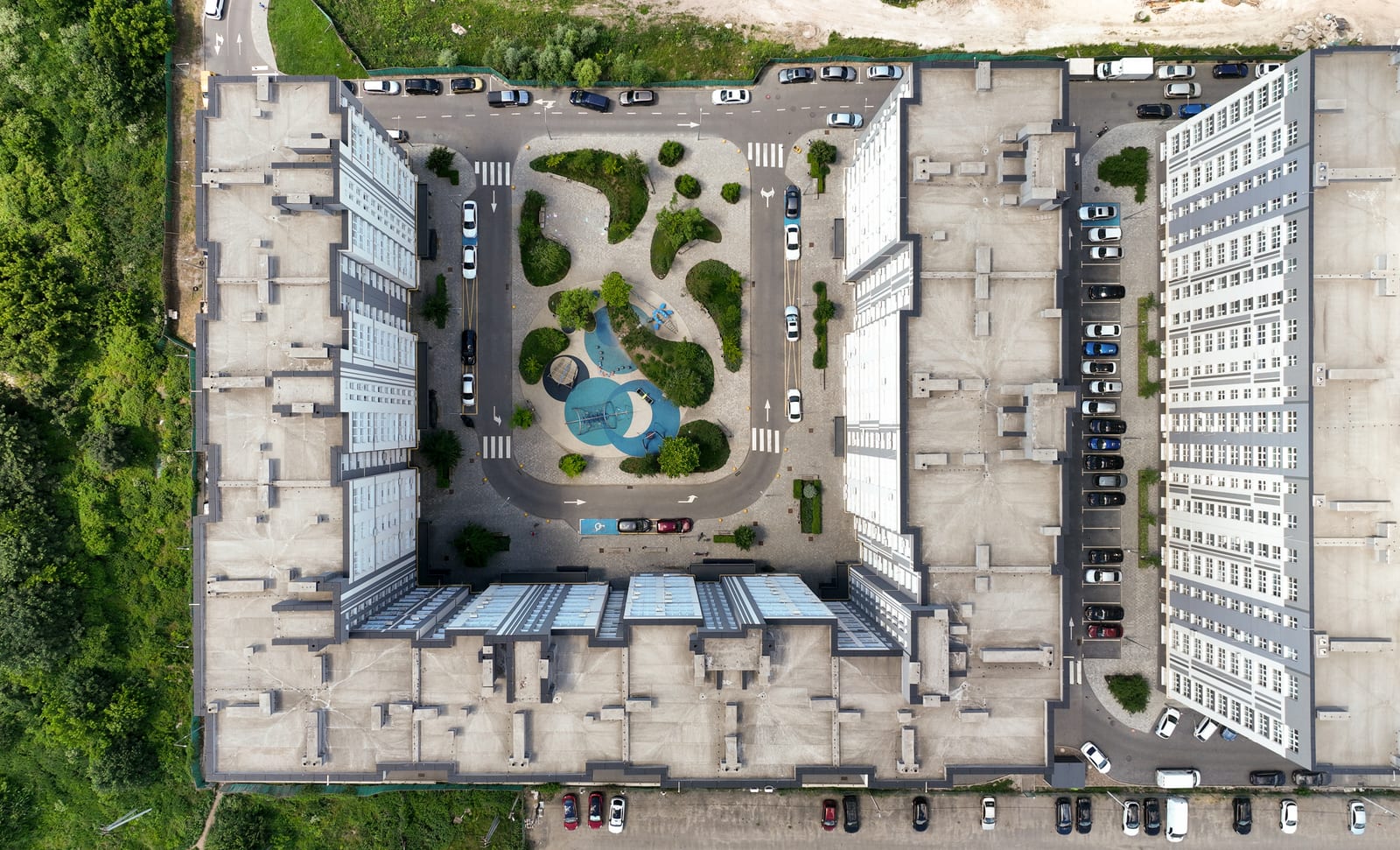 A closed courtyard of a SAVO district straight from above: the fountain in the middle, lawns, paths and the parking outside the ring of buildings