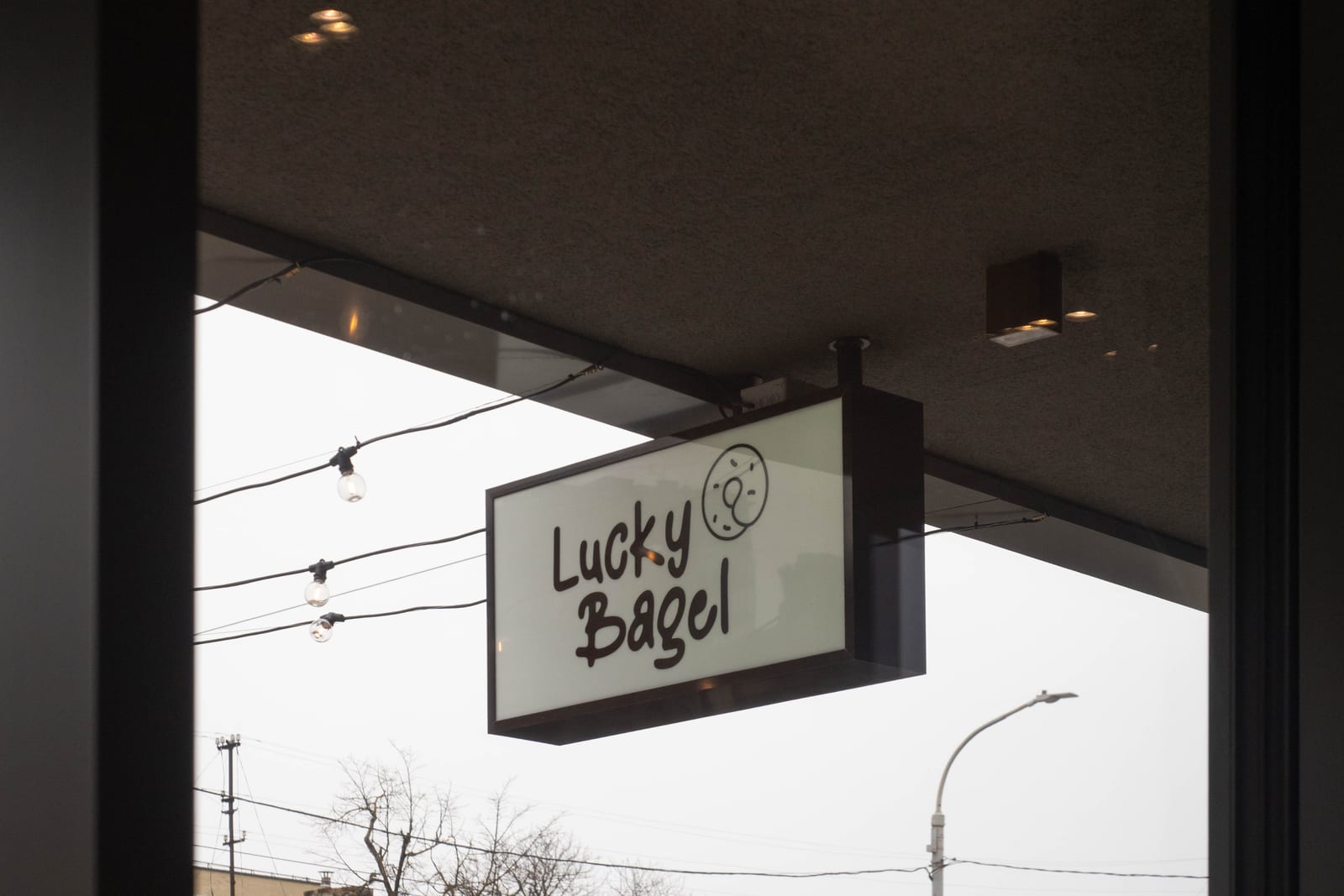 The hanging sign of the Lucky Bagel café in Vilnius, run by the group