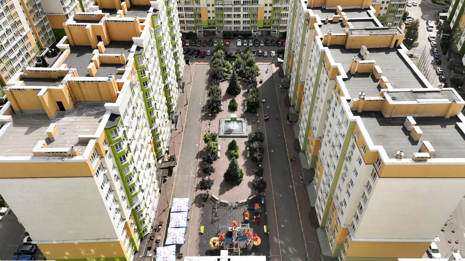 Looking down the full length of the planted boulevard of Evromisto by SAVO, with the fountain at its centre and the blocks on both sides