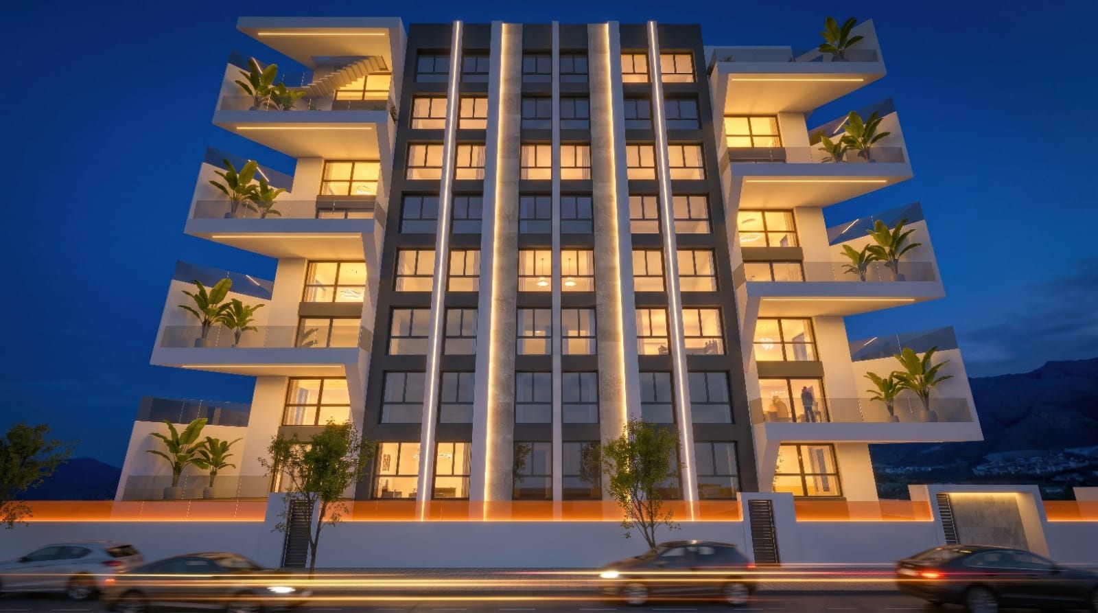 Villajoyosa Residence, project visualisation: the planned building at night, with lit windows and planted balconies
